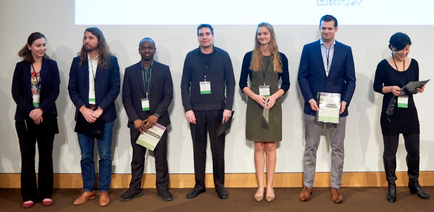 All participants of the Three Minute Thesis competition, standing on stage with certificates