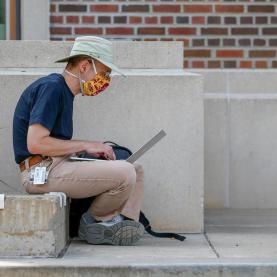 A UMN Employee works on his computer on campus