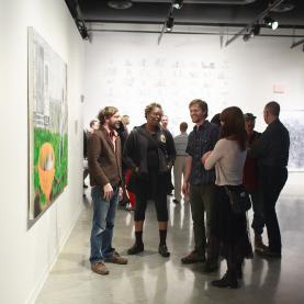 A group of people next to a painting